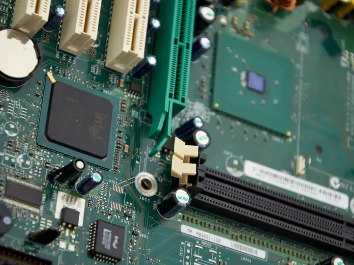 Close-up komponen motherboard komputer yang diperiksa teknisi